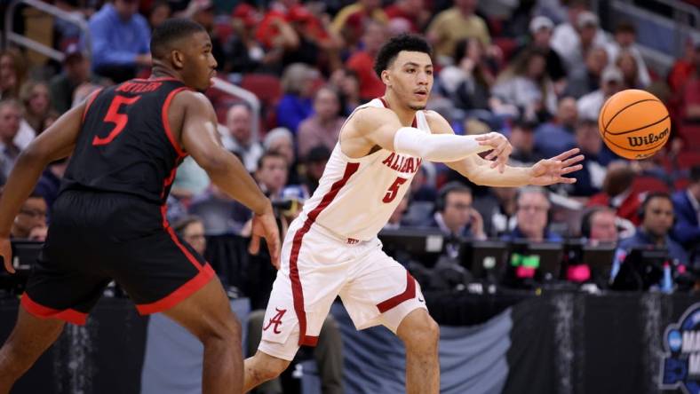 Mar 24, 2023; Louisville, KY, USA; Alabama Crimson Tide guard Jahvon Quinerly (5) passes in front of San Diego State Aztecs guard Lamont Butler (5) during the first half of the NCAA tournament round of sixteen at KFC YUM! Center. Mandatory Credit: Jordan Prather-USA TODAY Sports