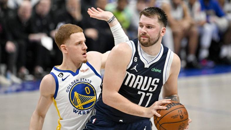 Mar 22, 2023; Dallas, Texas, USA; Golden State Warriors guard Donte DiVincenzo (0) and Dallas Mavericks guard Luka Doncic (77) in action during the game between the Dallas Mavericks and the Golden State Warriors at the American Airlines Center. Mandatory Credit: Jerome Miron-USA TODAY Sports