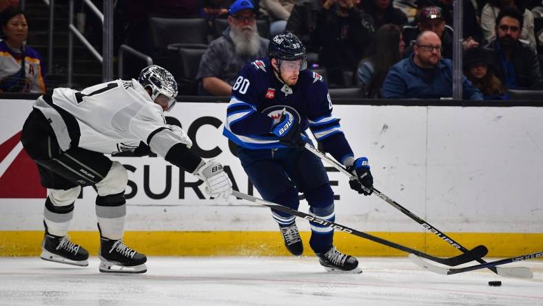 Mar 25, 2023; Los Angeles, California, USA; Winnipeg Jets left wing Pierre-Luc Dubois (80) moves the puck against Los Angeles Kings center Anze Kopitar (11) during the third period at Crypto.com Arena. Mandatory Credit: Gary A. Vasquez-USA TODAY Sports