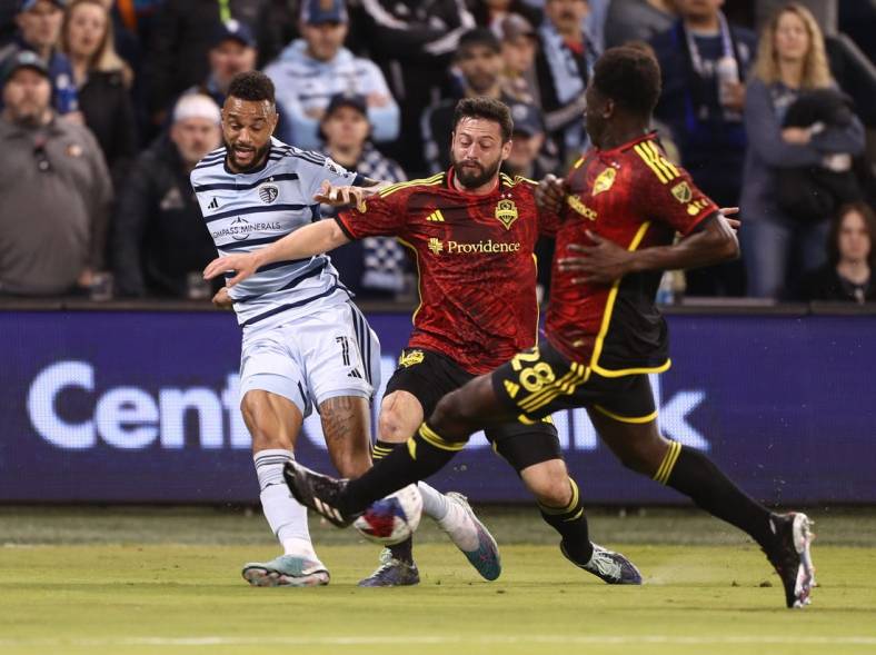 Mar 25, 2023; Kansas City, Kansas, USA; Sporting Kansas City forward Khiry Shelton (11) is defended by Seattle Sounders midfielder Joao Paulo (6) and Seattle Sounders defender Yeimar Gomez (28) in the first half at Children's Mercy Park. Mandatory Credit: William Purnell-USA TODAY Sports