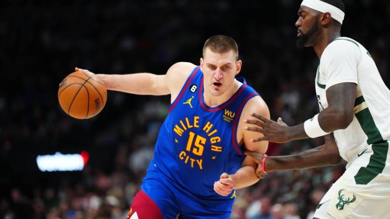 Mar 25, 2023; Denver, Colorado, USA; Denver Nuggets center Nikola Jokic (15) drives at Milwaukee Bucks forward Bobby Portis (9) during the second half at Ball Arena. Mandatory Credit: Ron Chenoy-USA TODAY Sports