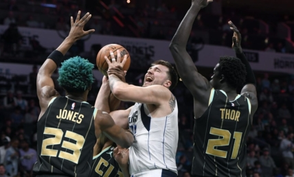 Mar 26, 2023; Charlotte, North Carolina, USA;  Dallas Mavericks guard Luka Doncic (77) shoots as he is defended by Charlotte Hornets forward center Kai Jones (23) and forward JT Thor (21) during the first half at the Spectrum Center. Mandatory Credit: Sam Sharpe-USA TODAY Sports