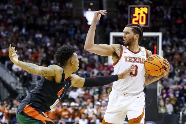 Mar 26, 2023; Kansas City, MO, USA;  Texas Longhorns forward Timmy Allen (0) controls the ball against Miami Hurricanes guard Jordan Miller (11) in the first half at the T-Mobile Center. Mandatory Credit: Jay Biggerstaff-USA TODAY Sports