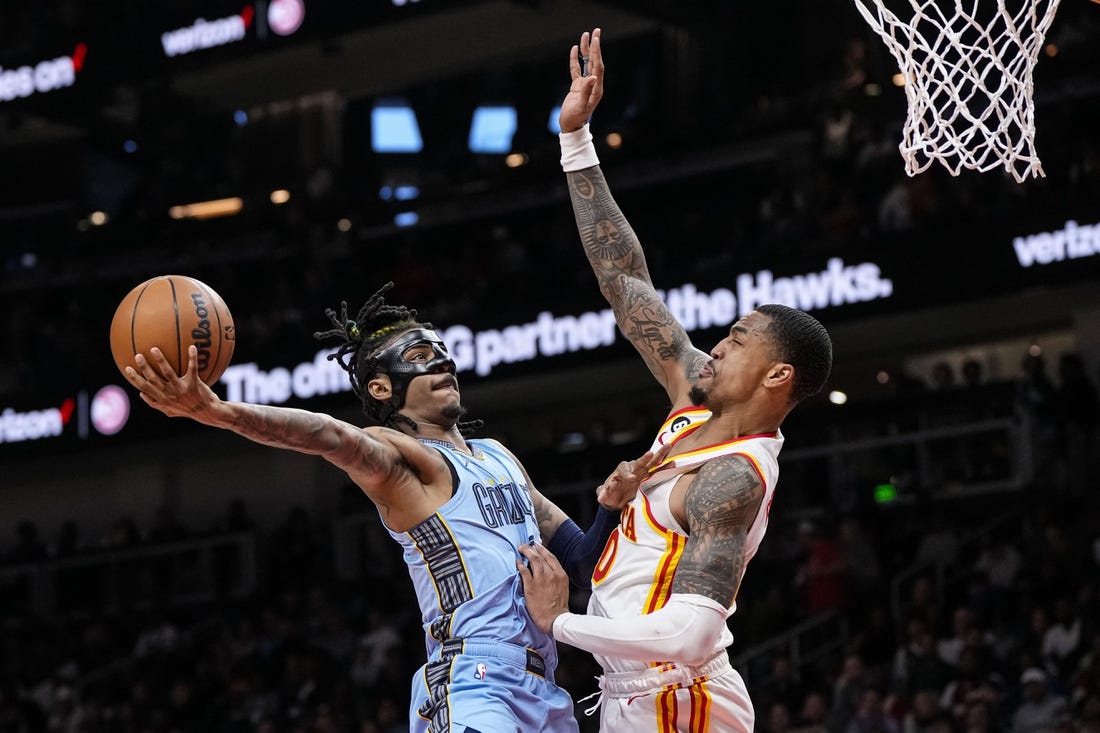 Mar 26, 2023; Atlanta, Georgia, USA; Memphis Grizzlies guard Ja Morant (12) goes to the basket against Atlanta Hawks forward John Collins (20) during the second half at State Farm Arena. Mandatory Credit: Dale Zanine-USA TODAY Sports