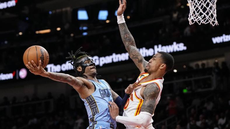 Mar 26, 2023; Atlanta, Georgia, USA; Memphis Grizzlies guard Ja Morant (12) goes to the basket against Atlanta Hawks forward John Collins (20) during the second half at State Farm Arena. Mandatory Credit: Dale Zanine-USA TODAY Sports