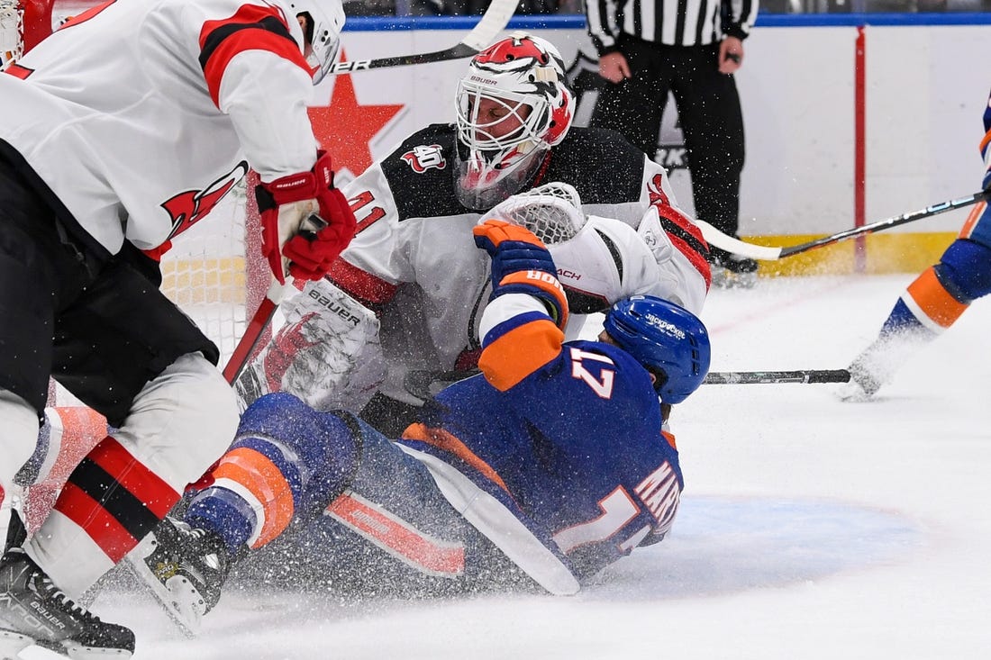 Mar 27, 2023; Elmont, New York, USA;  New York Islanders left wing Matt Martin (17) falls into New Jersey Devils goaltender Vitek Vanecek (41) during the second period at UBS Arena. Mandatory Credit: Dennis Schneidler-USA TODAY Sports