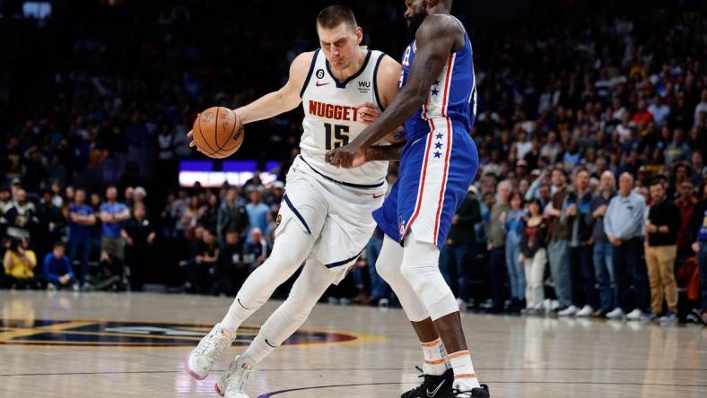 Mar 27, 2023; Denver, Colorado, USA; Denver Nuggets center Nikola Jokic (15) drives to the basket against Philadelphia 76ers center Dewayne Dedmon (14) in the first quarter at Ball Arena. Mandatory Credit: Isaiah J. Downing-USA TODAY Sports