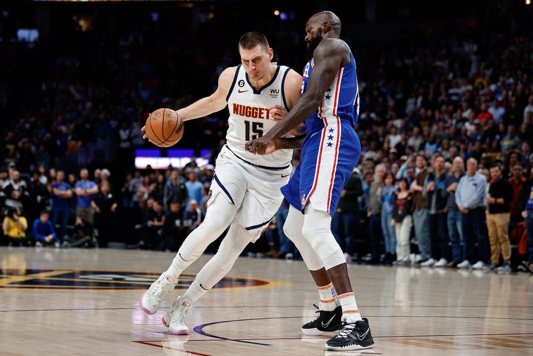 Mar 27, 2023; Denver, Colorado, USA; Denver Nuggets center Nikola Jokic (15) drives to the basket against Philadelphia 76ers center Dewayne Dedmon (14) in the first quarter at Ball Arena. Mandatory Credit: Isaiah J. Downing-USA TODAY Sports