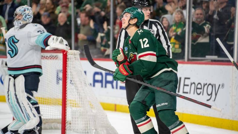 Mar 27, 2023; Saint Paul, Minnesota, USA; Minnesota Wild left wing Matt Boldy (12) looks at the replay of his second goal of the game against the Seattle Kraken in the second period at Xcel Energy Center. Mandatory Credit: Matt Blewett-USA TODAY Sports