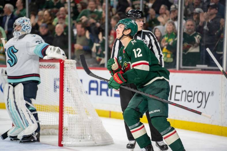 Mar 27, 2023; Saint Paul, Minnesota, USA; Minnesota Wild left wing Matt Boldy (12) looks at the replay of his second goal of the game against the Seattle Kraken in the second period at Xcel Energy Center. Mandatory Credit: Matt Blewett-USA TODAY Sports