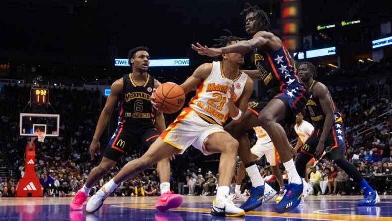 Mar 28, 2023; Houston, TX, USA; East guard DJ Wagner (center) drives to the basket against West forward Baye Fall during the McDonald's All American Boy's high school basketball game at Toyota Center. Mandatory Credit: Mark J. Rebilas-USA TODAY Sports