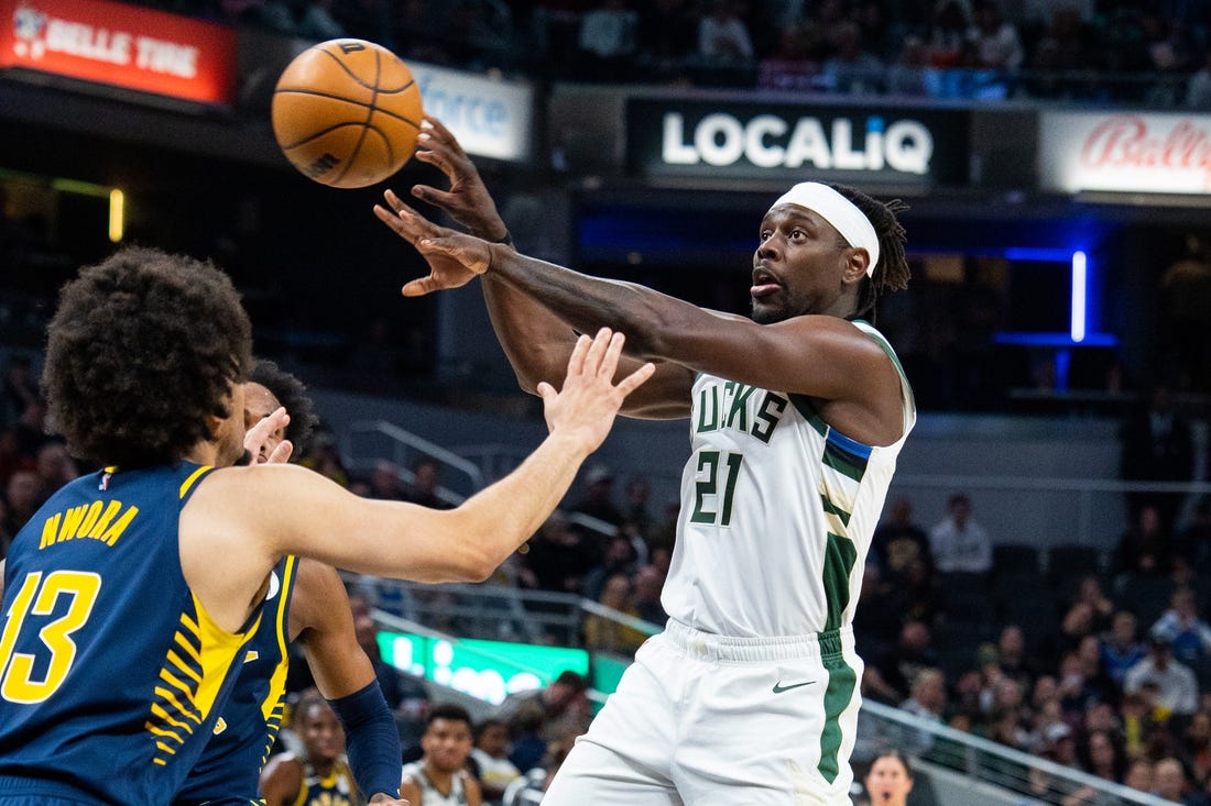 Mar 29, 2023; Indianapolis, Indiana, USA; Milwaukee Bucks guard Jrue Holiday (21) passes the ball while Indiana Pacers forward Jordan Nwora (13) defends in the second quarter at Gainbridge Fieldhouse. Mandatory Credit: Trevor Ruszkowski-USA TODAY Sports