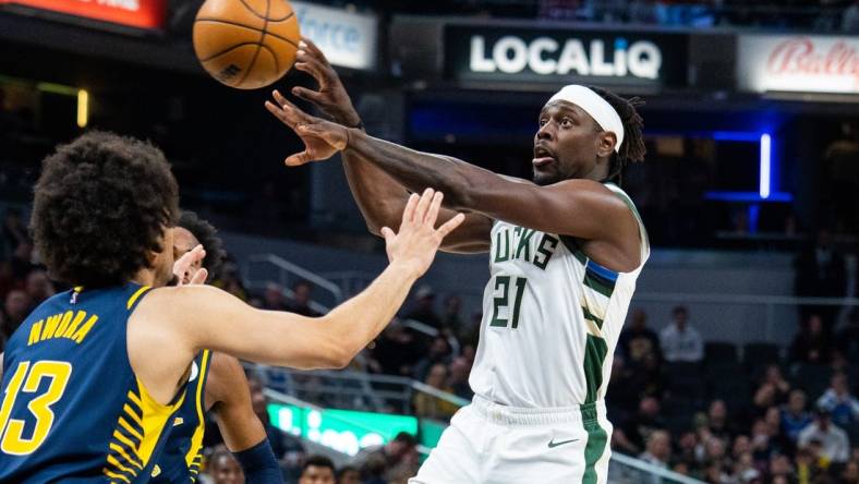 Mar 29, 2023; Indianapolis, Indiana, USA; Milwaukee Bucks guard Jrue Holiday (21) passes the ball while Indiana Pacers forward Jordan Nwora (13) defends in the second quarter at Gainbridge Fieldhouse. Mandatory Credit: Trevor Ruszkowski-USA TODAY Sports