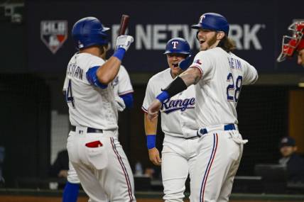Mar 30, 2023; Arlington, Texas, USA; Texas Rangers right fielder Robbie Grossman (4) and catcher Jonah Heim (28) celebrates after Grossman hits a two run home run against the Philadelphia Phillies during the fourth inning at Globe Life Field. Mandatory Credit: Jerome Miron-USA TODAY Sports