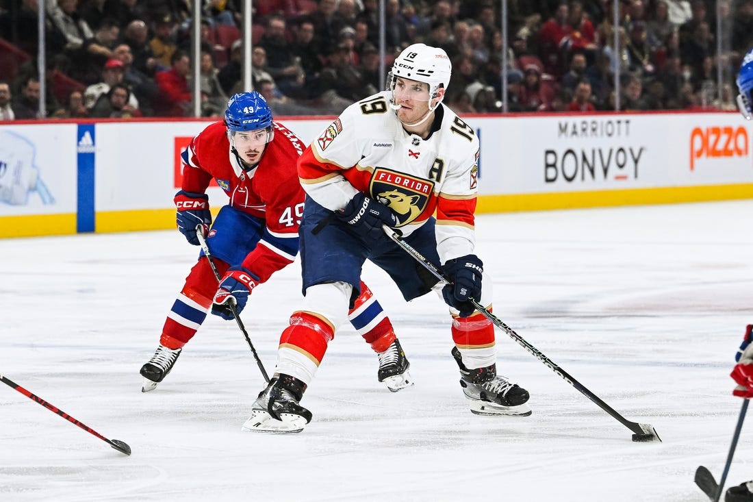 Mar 30, 2023; Montreal, Quebec, CAN; Florida Panthers left wing Matthew Tkachuk (19) plays the puck against Montreal Canadiens left wing Rafael Harvey-Pinard (49) during the third period at Bell Centre. Mandatory Credit: David Kirouac-USA TODAY Sports