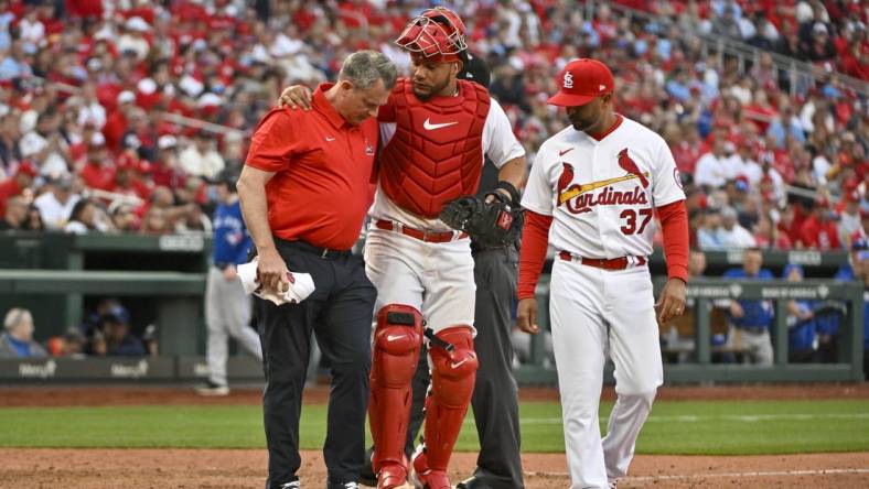 Mar 30, 2023; St. Louis, Missouri, USA;  St. Louis Cardinals catcher Willson Contreras (40) is helped off the field by a trainer after taking a ball off the the knee during the eighth inning against the Toronto Blue Jays at Busch Stadium. Mandatory Credit: Jeff Curry-USA TODAY Sports