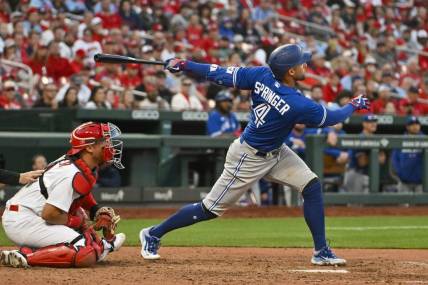 Mar 30, 2023; St. Louis, Missouri, USA;  Toronto Blue Jays right fielder George Springer (4) hits a single against the St. Louis Cardinals during the ninth inning at Busch Stadium. Mandatory Credit: Jeff Curry-USA TODAY Sports