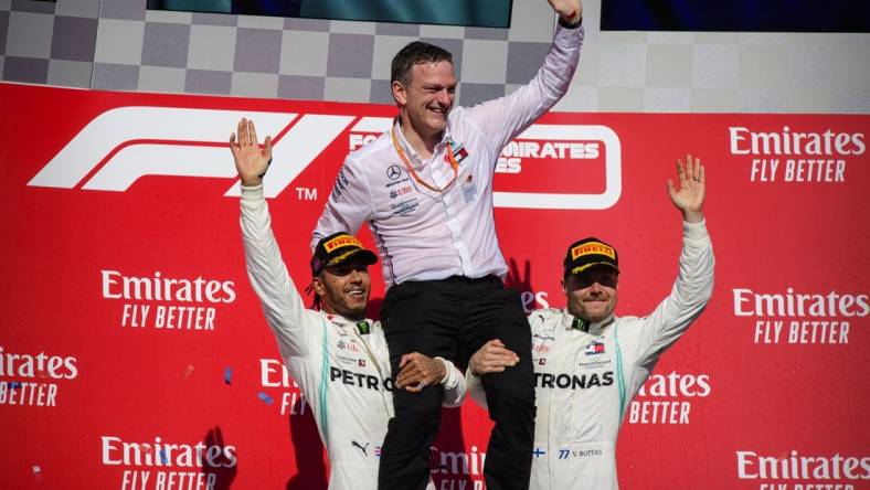 Nov 3, 2019; Austin, TX, USA; Mercedes AMG Petronas Motorsport designer James Allison is lifted up by Mercedes AMG Petronas Motorsport driver Lewis Hamilton (left) of Great Britain and Mercedes AMG Petronas Motorsport driver Valtteri Bottas (right) of Finland during the United States Grand Prix at Circuit of the Americas. Mandatory Credit: Jerome Miron-USA TODAY Sports