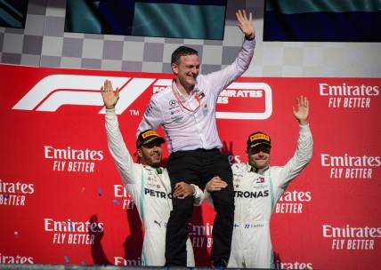 Nov 3, 2019; Austin, TX, USA; Mercedes AMG Petronas Motorsport designer James Allison is lifted up by Mercedes AMG Petronas Motorsport driver Lewis Hamilton (left) of Great Britain and Mercedes AMG Petronas Motorsport driver Valtteri Bottas (right) of Finland during the United States Grand Prix at Circuit of the Americas. Mandatory Credit: Jerome Miron-USA TODAY Sports