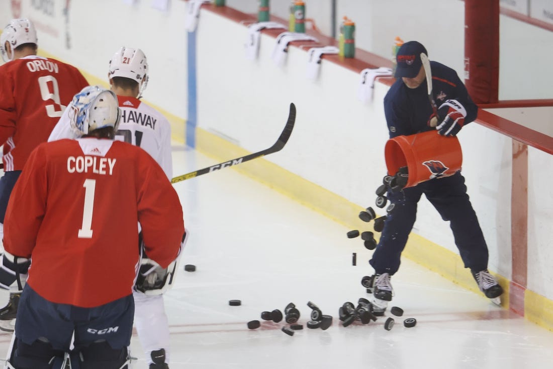 Jul 15, 2020; Arlington, Virginia, USA; Washington Capitals assistant coach Blaine Forsythe dumps pucks onto the ice during an NHL workout at MedStar Capitals Iceplex. Mandatory Credit: Geoff Burke-USA TODAY Sports