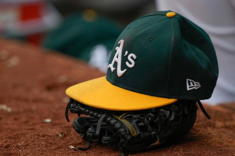 Jun 30, 2021; Oakland, California, USA;  General view of the Oakland Athletics hat and glove during the third inning against the Texas Rangers at RingCentral Coliseum. Mandatory Credit: Stan Szeto-USA TODAY Sports