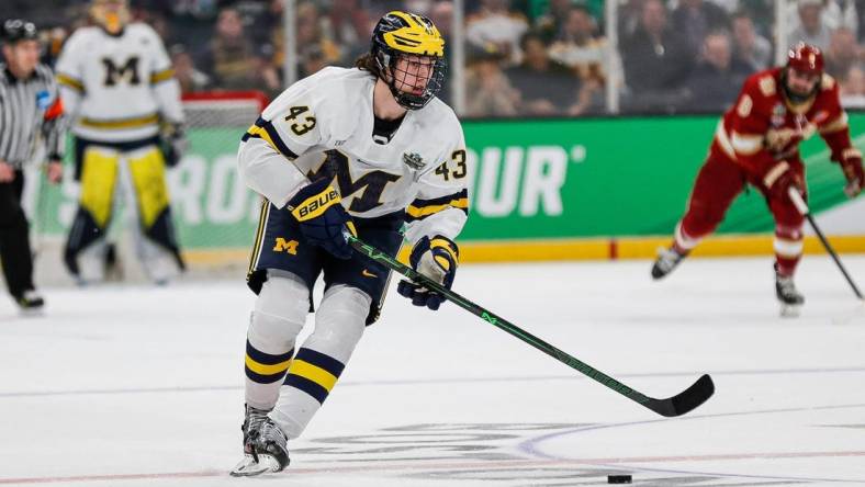 Michigan defenseman Luke Hughes (43) looks to pass against Denver during the first period of the Frozen Four semifinal at the TD Garden in Boston, Mass. on Thursday., April 7, 2022.