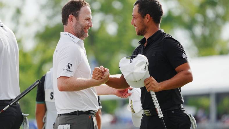 Apr 24, 2022; Avondale, Louisiana, USA; Xander Schauffele (right) embraces Patrick Cantlay (left) on the 18th green during the final round of the Zurich Classic of New Orleans golf tournament. Mandatory Credit: Andrew Wevers-USA TODAY Sports