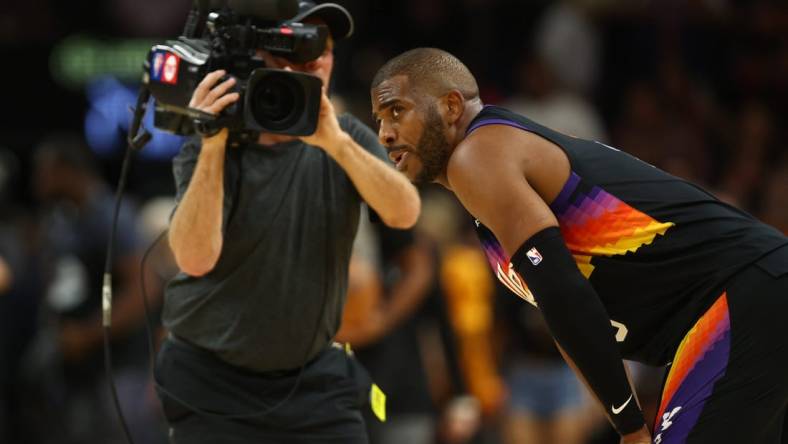 Apr 26, 2022; Phoenix, Arizona, USA; A TV cameraman records Phoenix Suns guard Chris Paul (3) against the New Orleans Pelicans during game five of the first round for the 2022 NBA playoffs at Footprint Center. Mandatory Credit: Mark J. Rebilas-USA TODAY Sports