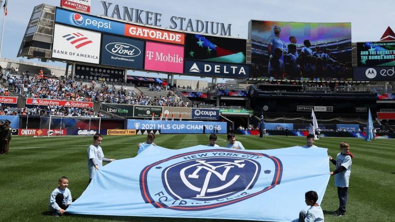 May 1, 2022; New York, New York, USA; Young fans hold a New York City FC banner on the pitch before the game against the San Jose Earthquakes at Yankee Stadium. Mandatory Credit: Vincent Carchietta-USA TODAY Sports