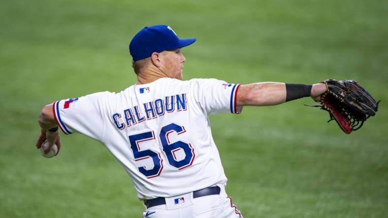 Jul 16, 2022; Arlington, Texas, USA; Texas Rangers left fielder Kole Calhoun (56) throws the ball into the infield during the sixth inning against the Seattle Mariners at Globe Life Field. Mandatory Credit: Jerome Miron-USA TODAY Sports