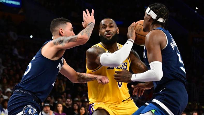 Oct 12, 2022; Los Angeles, California, USA;  Los Angeles Lakers forward LeBron James (6) drives through Minnesota Timberwolves Jaden McDaniels (3) and Minnesota Timberwolves guard Austin Rivers (25) during the third quarter at Crypto.com Arena. Mandatory Credit: Richard Mackson-USA TODAY Sports