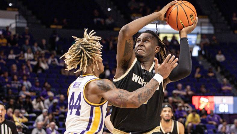 Nov 27, 2022; Baton Rouge, Louisiana, USA; Wofford Terriers forward B.J. Mack (33) drives to the basket against LSU Tigers guard Adam Miller (44) during the second half at Pete Maravich Assembly Center. Mandatory Credit: Stephen Lew-USA TODAY Sports