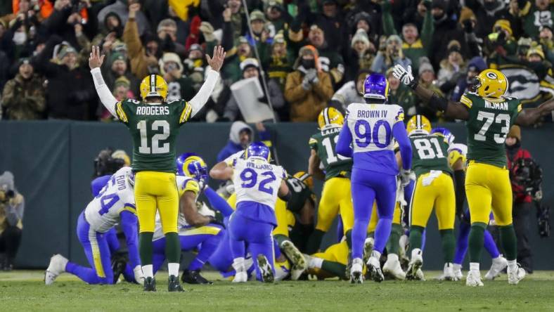 Dec 19, 2022; Green Bay, Wisconsin, USA; Green Bay Packers quarterback Aaron Rodgers (12) reacts as running back AJ Dillon scores a touchdown against the Los Angeles Rams at Lambeau Field. Mandatory Credit: Tork Mason-USA TODAY Sports