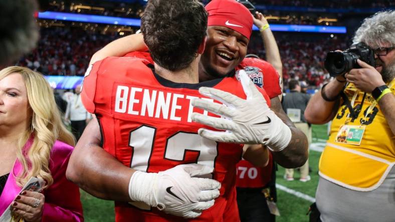 Dec 31, 2022; Atlanta, Georgia, USA; Georgia Bulldogs quarterback Stetson Bennett (13) and defensive lineman Jalen Carter (88) celebrate after a victory against Ohio State Buckeyes in the 2022 Peach Bowl at Mercedes-Benz Stadium. Mandatory Credit: Brett Davis-USA TODAY Sports