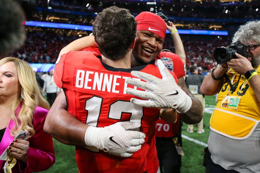 Dec 31, 2022; Atlanta, Georgia, USA; Georgia Bulldogs quarterback Stetson Bennett (13) and defensive lineman Jalen Carter (88) celebrate after a victory against Ohio State Buckeyes in the 2022 Peach Bowl at Mercedes-Benz Stadium. Mandatory Credit: Brett Davis-USA TODAY Sports