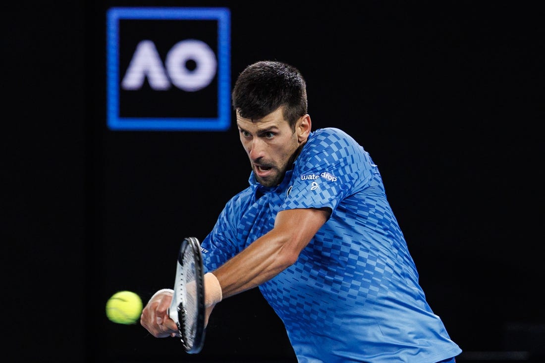 Jan 29, 2023; Melbourne, Victoria, Australia; Novak Djokovic of Serbia hits a shot against Stefanos Tsitsipas of Greece at the men's final on day fourteen of the 2023 Australian Open tennis tournament at Melbourne Park. Mandatory Credit: Mike Frey-USA TODAY Sports