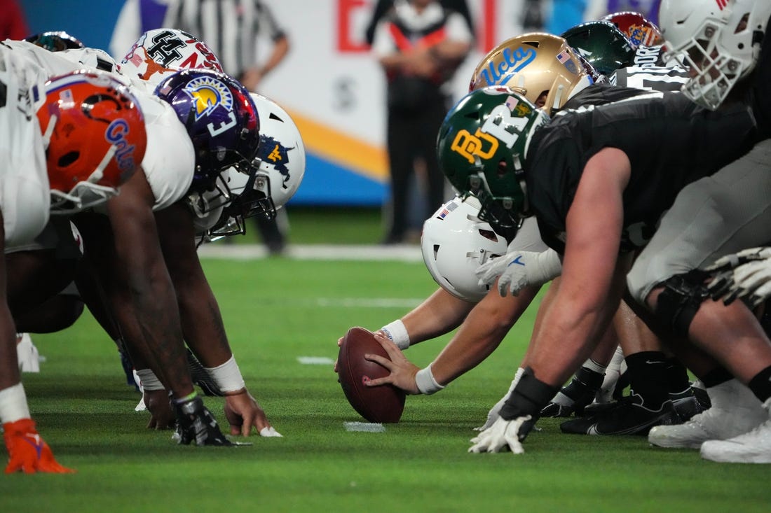 Feb 2, 2023; Las Vegas, NV, USA; A general overall view of helmets at the line of scrimmage as West long snapper Chris Stoll of Penn State snaps the ball against the East during the Shrine Bowl at Allegiant Stadium. Mandatory Credit: Kirby Lee-USA TODAY Sports