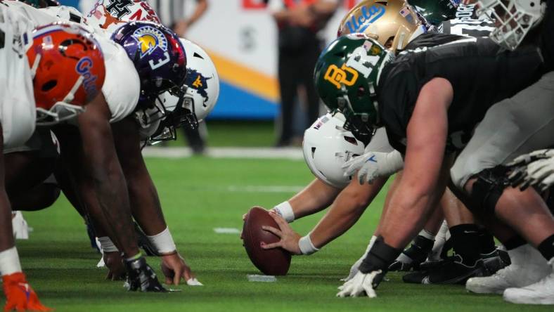 Feb 2, 2023; Las Vegas, NV, USA; A general overall view of helmets at the line of scrimmage as West long snapper Chris Stoll of Penn State snaps the ball against the East during the Shrine Bowl at Allegiant Stadium. Mandatory Credit: Kirby Lee-USA TODAY Sports