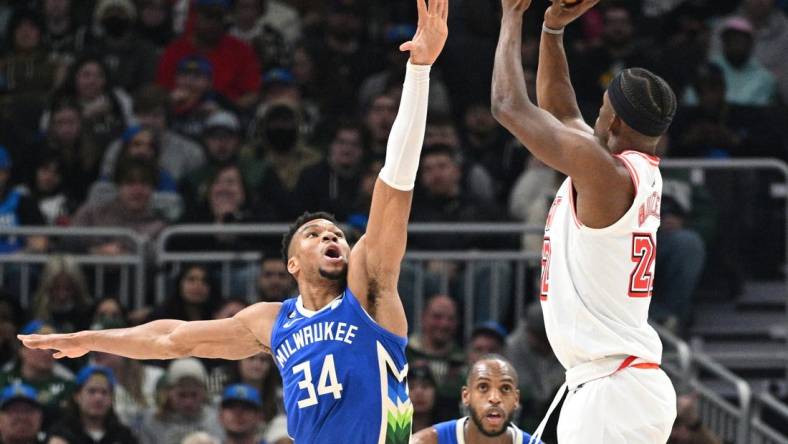 Feb 4, 2023; Milwaukee, Wisconsin, USA; Miami Heat forward Jimmy Butler (22) shoots the ball against Milwaukee Bucks forward Giannis Antetokounmpo (34) in the first half at Fiserv Forum. Mandatory Credit: Michael McLoone-USA TODAY Sports