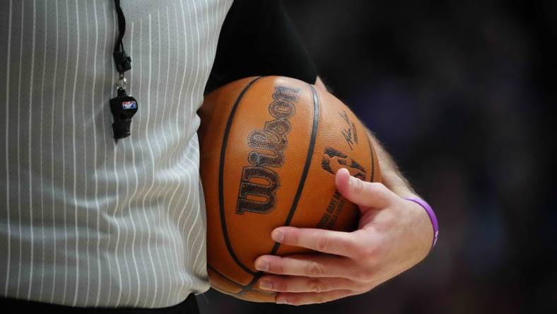 Feb 15, 2023; Denver, Colorado, USA; A detailed view of the game basketball held by referee Brett Nansel (44) during the second quarter between the Dallas Mavericks against the Denver Nuggets at Ball Arena. Mandatory Credit: Ron Chenoy-USA TODAY Sports