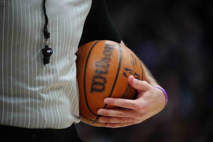 Feb 15, 2023; Denver, Colorado, USA; A detailed view of the game basketball held by referee Brett Nansel (44) during the second quarter between the Dallas Mavericks against the Denver Nuggets at Ball Arena. Mandatory Credit: Ron Chenoy-USA TODAY Sports