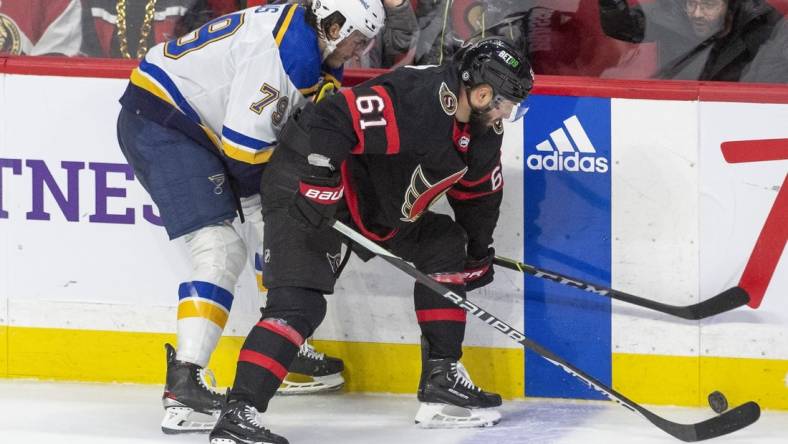 Feb 19, 2023; Ottawa, Ontario, CAN; St. Louis Blues left wing Sammy Blais (79) fights for the puck against Ottawa Senators center Derick Brassard (61) in the third period at the Canadian Tire Centre. Mandatory Credit: Marc DesRosiers-USA TODAY Sports