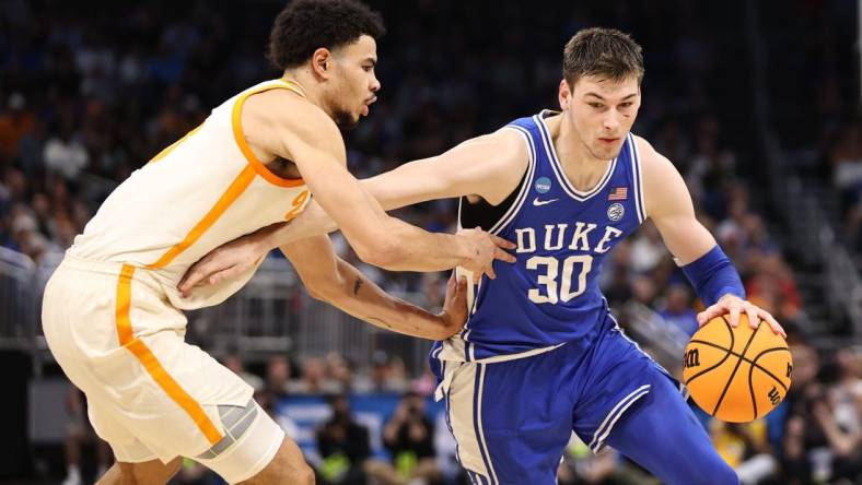 Mar 18, 2023; Orlando, FL, USA; Duke Blue Devils center Kyle Filipowski (30) drives against Tennessee Volunteers forward Olivier Nkamhoua (13) during the first half in the second round of the 2023 NCAA Tournament at Legacy Arena. Mandatory Credit: Matt Pendleton-USA TODAY Sports