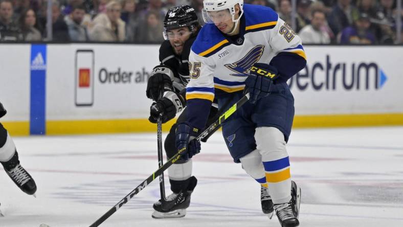 Mar 26, 2023; Los Angeles, California, USA;   St. Louis Blues center Jordan Kyrou (25) and Los Angeles Kings left wing Alex Iafallo (19) battle for the puck in the third period at Crypto.com Arena. Mandatory Credit: Jayne Kamin-Oncea-USA TODAY Sports