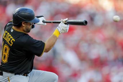 Mar 30, 2023; Cincinnati, Ohio, USA; Pittsburgh Pirates catcher Austin Hedges (18) bunts against the Cincinnati Reds in the eighth inning at Great American Ball Park. Mandatory Credit: Katie Stratman-USA TODAY Sports