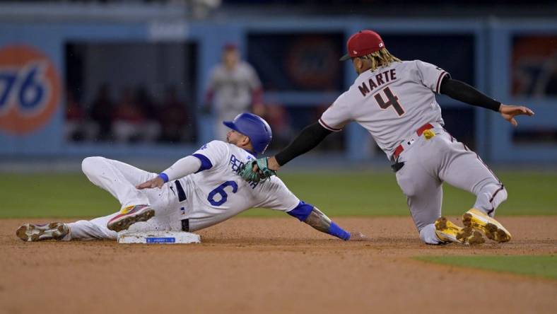 Mar 31, 2023; Los Angeles, California, USA;  Los Angeles Dodgers left fielder David Peralta (6) is tagged out by Arizona Diamondbacks second baseman Ketel Marte (4) on a stolen base attempt in the second inning at Dodger Stadium. Mandatory Credit: Jayne Kamin-Oncea-USA TODAY Sports
