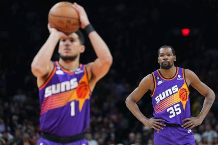 Mar 31, 2023; Phoenix, Arizona, USA; Phoenix Suns forward Kevin Durant (35) watches as Phoenix Suns guard Devin Booker (1) shoots a free throw against the Denver Nuggets during the first half at Footprint Center. Mandatory Credit: Joe Camporeale-USA TODAY Sports