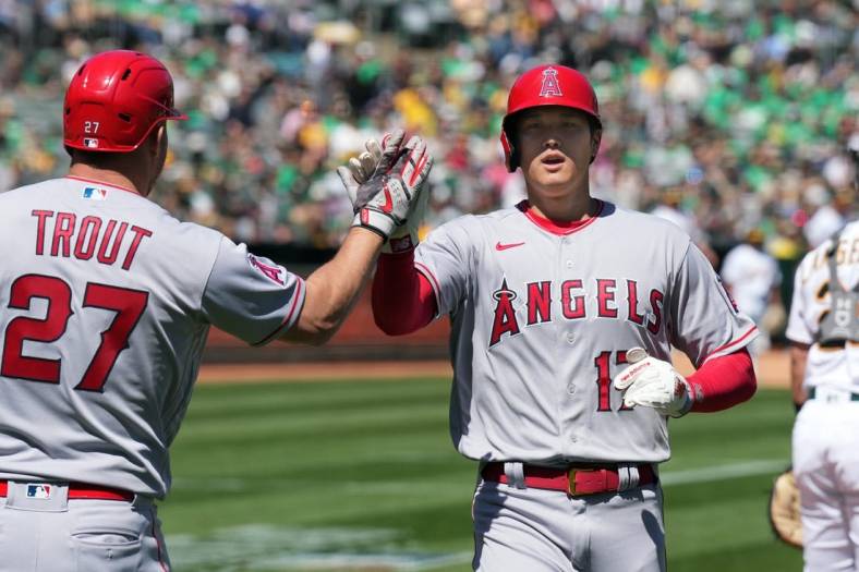 Apr 1, 2023; Oakland, California, USA; Los Angeles Angels designated hitter Shohei Ohtani (17) is congratulated by center fielder Mike Trout (27) after scoring a run against the Oakland Athletics during the third inning at RingCentral Coliseum. Mandatory Credit: Darren Yamashita-USA TODAY Sports