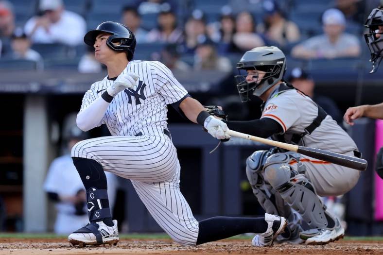Apr 1, 2023; Bronx, New York, USA; New York Yankees shortstop Anthony Volpe (11) follows through on a single against the San Francisco Giants during the second inning at Yankee Stadium. The hit was hit first major league hit. Mandatory Credit: Brad Penner-USA TODAY Sports