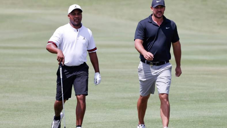 Apr 1, 2023; Orlando, Florida, USA; Harold Varner III of the RangeGoats (left) and Brooks Koepka of the Smash golf club walk onto the fourth green during the second round of a LIV Golf event at Orange County National. Mandatory Credit: Reinhold Matay-USA TODAY Sports